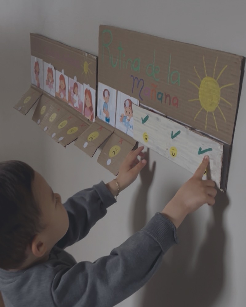 Child pointing at a picture-based morning routine board